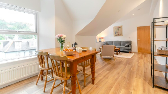 Dining table in the foreground with the living room behind — Apartment 9